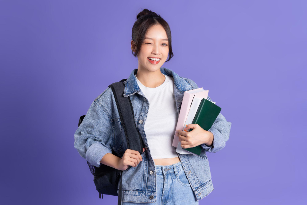 portrait-beautiful-asian-schoolgirl-wearing-backpack-purple-background
